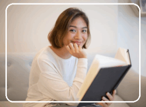 222smiling young woman reading book sofa home 1262 18112 e1754882499933 300x221 1